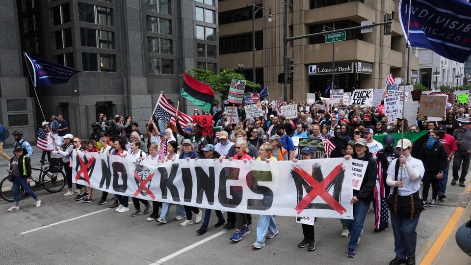 Peaceful protesters march with a large "No Kings" banner opposing Trump's self-coronation parade in 2025.